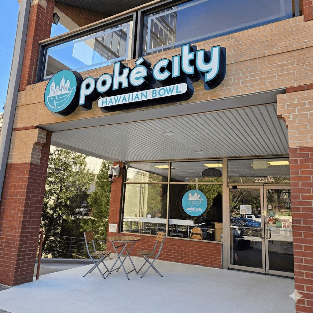 Poké City Hawaiian Bowl restaurant storefront with brick walls, glass windows, and outdoor seating.